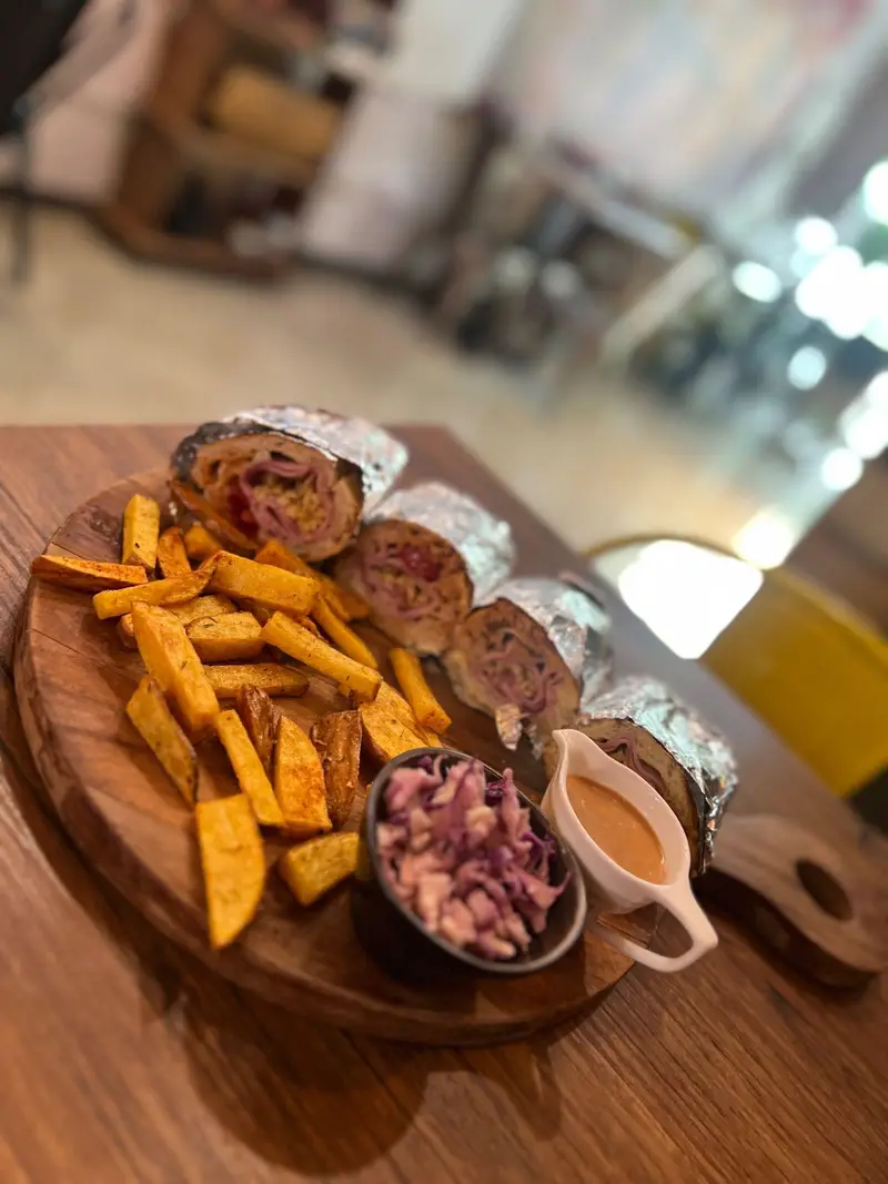 ساندویچ‌های ویژه و لذیذ کافه پارس، به همراه سیب‌زمینی سرخ‌کرده، سالاد کلم بنفش و سس مخصوص. لذت در کافه پارس.