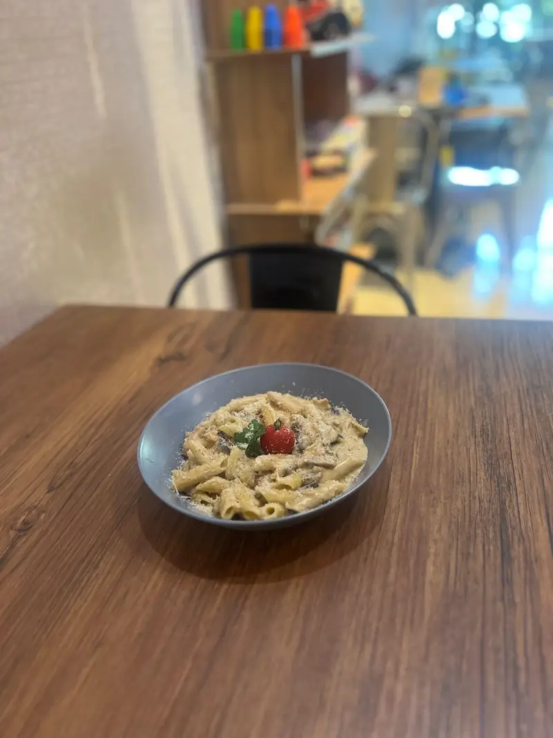 پاستا پنه خامه‌ای محبوب کافه پارس با پنیر پارمزان و گوجه گیلاسی، غذایی بی‌نظیر برای تجربه در فضای گرم کافه.