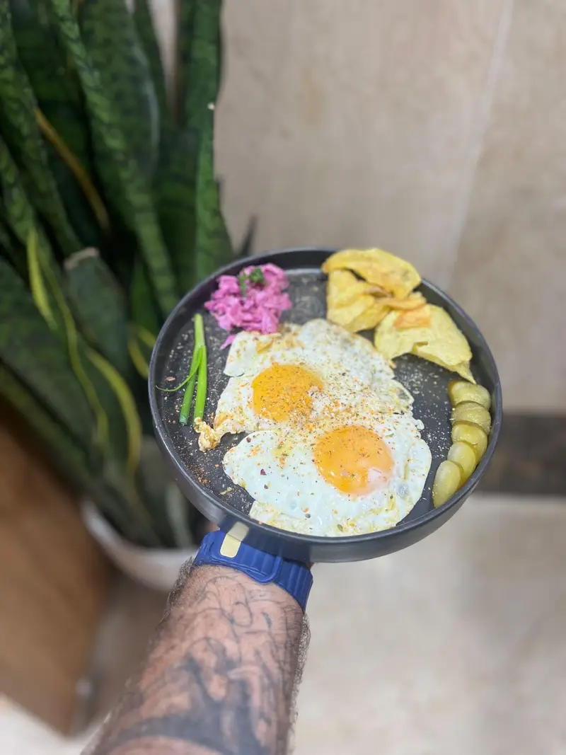 صبحانه اشتهاآور کافه پارس: دو نیمرو با ادویه، چیپس طلایی، ترشی خیارشور و سالاد کلم بنفش. انتخابی بی‌نظیر برای شروع روز در کافه پارس.