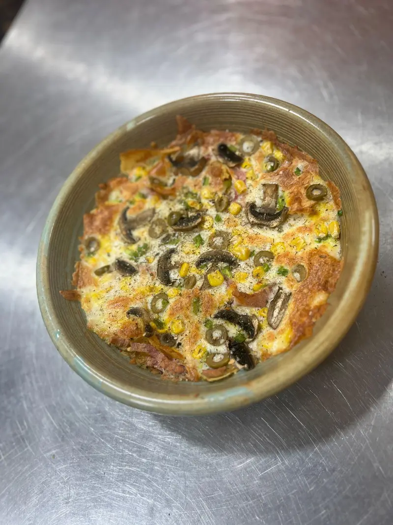یک غذای گرم و لذیذ از منوی کافه پارس: خوراکی با قارچ، ذرت و زیتون، ایده‌آل برای صبحانه یا برانچ. تجربه‌ای خوشمزه.