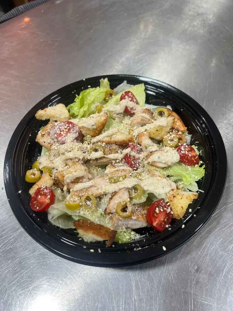 سالاد سزار خوشمزه و تازه کافه پارس با مرغ گریل، کاهو، گوجه گیلاسی، زیتون، نان تست و سس مخصوص برای یک وعده سالم و دلپذیر.