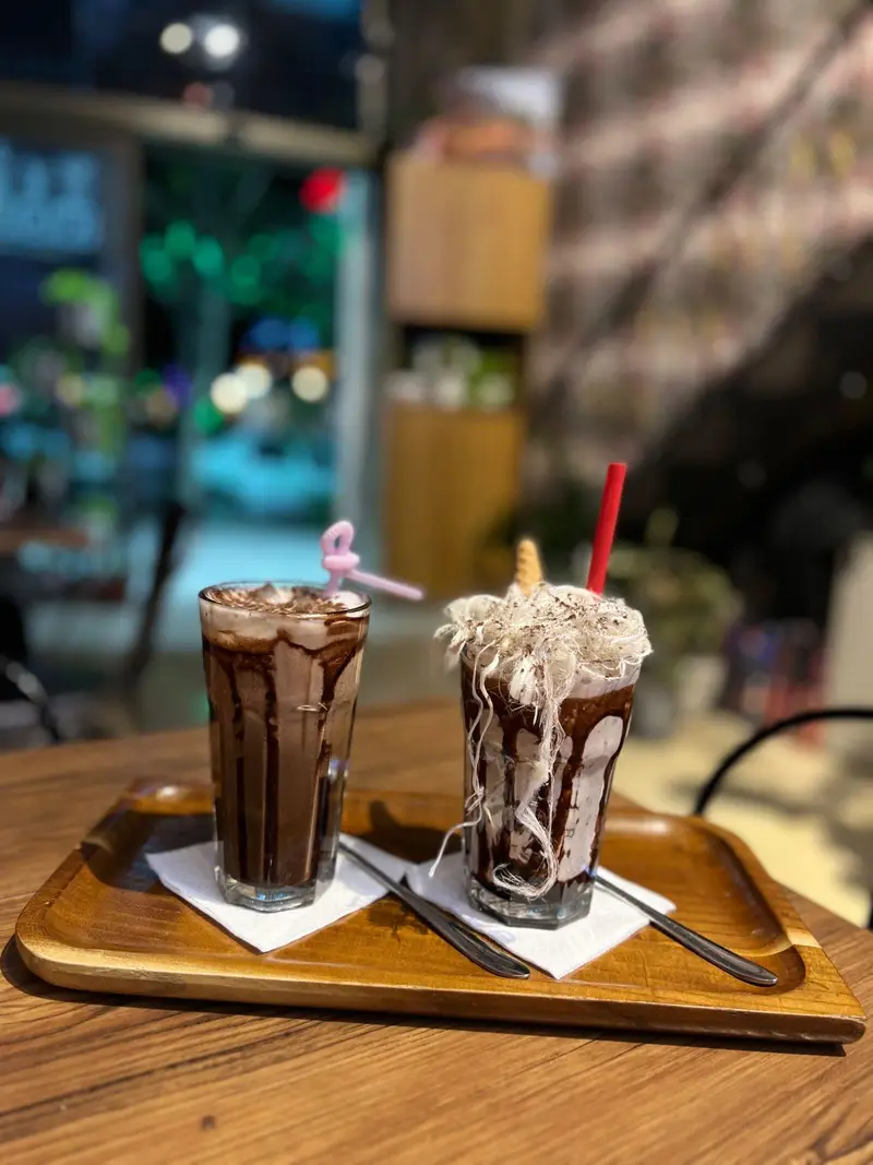 نوشیدنی‌های خنک و خوشمزه شیک شکلات و آیس چاکلت با تزئین زیبا در فضای دلنشین کافه پارس. تجربه‌ای شیرین و لذت‌بخش.