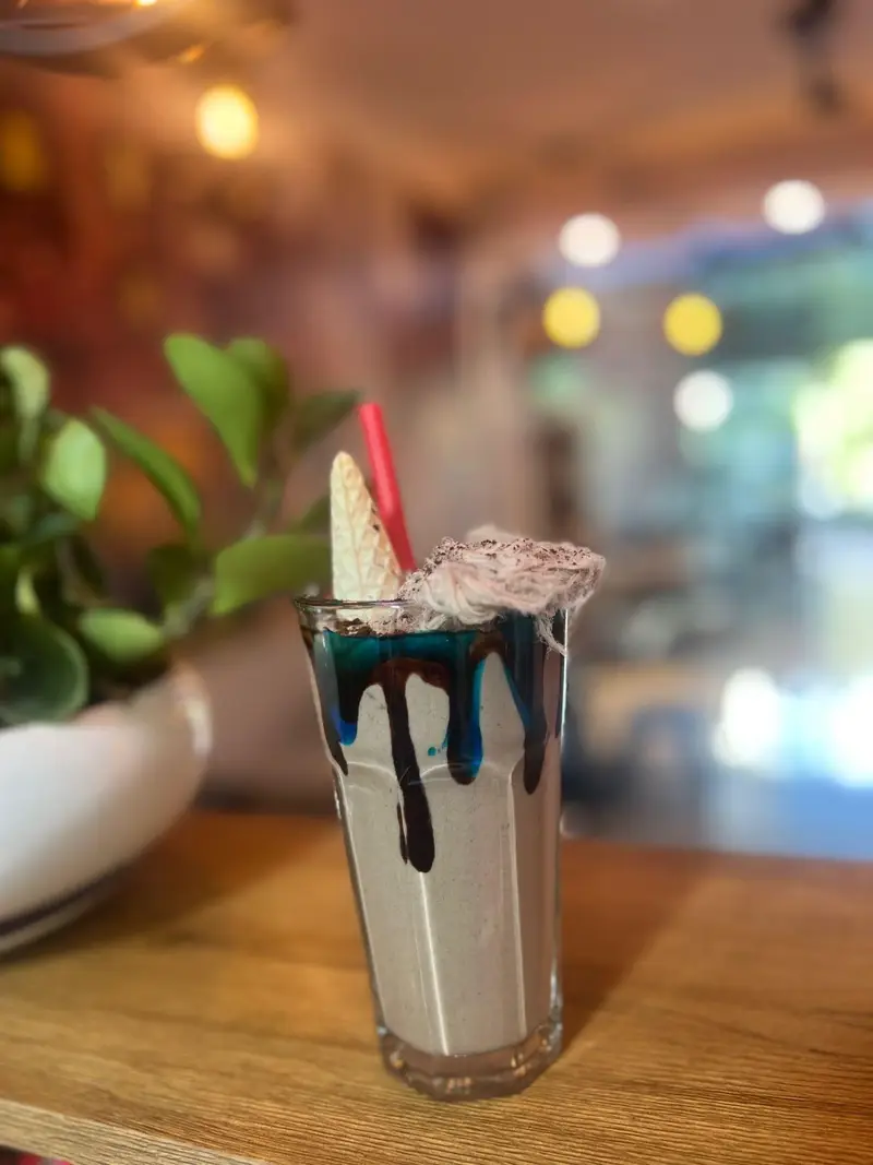 میلک شیک خاص و تابستانی کافه پارس، با سس‌های رنگارنگ و پشمک و ویفر. نوشیدنی لذیذ و دلپذیر برای تجربه ای متفاوت در کافه.