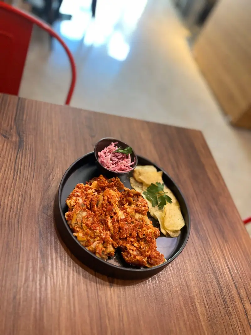 صبحانه لذیذ کافه پارس: شاک شوکا یا املت تخم مرغ با سس قرمز، چیپس ترد و سالاد کلم در محیطی دلنشین.