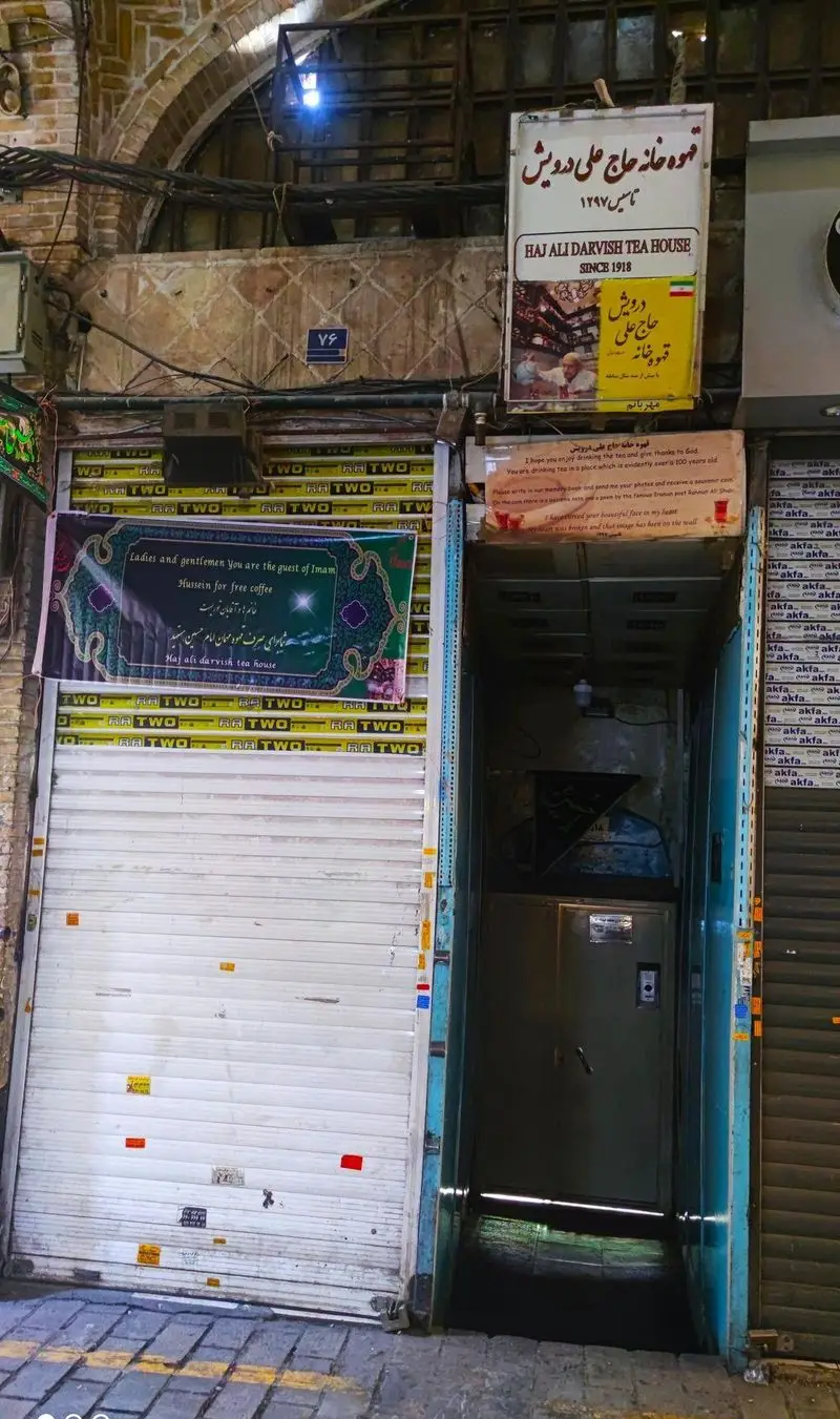 نمای ورودی قهوه خانه تاریخی و سنتی حاج علی درویش در قلب بازار بزرگ تهران. این مکان که از سال ۱۹۱۸ دایر است، چای و قهوه ارائه می‌دهد.