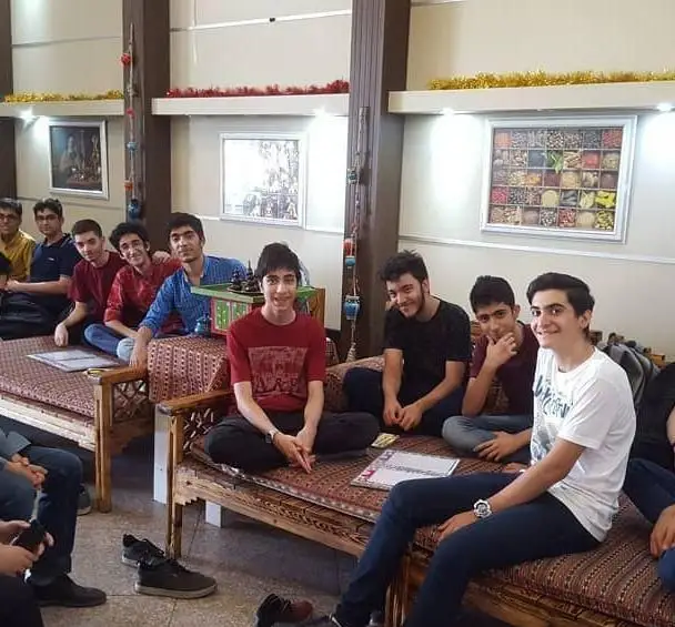 گروه جوانان در سفره خانه و سنت سرای حافظ بر روی تخت‌های سنتی نشسته و از دورهمی و فضای دلنشین لذت می‌برند.