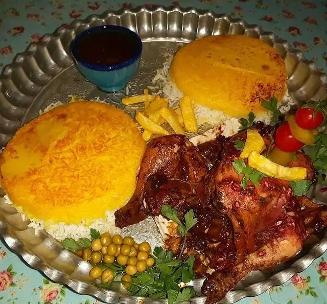 غذای سنتی و خوشمزه سفره خانه وسنت سرای حافظ: مرغ اناری لذیذ، ته چین زعفرانی، برنج، سیب زمینی سرخ کرده و دورچین اشتهاآور.