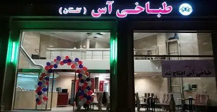 نمای شبانه طباخی آس (گلستان) با تابلوی نئون صورتی و ورودی مزین به بادکنک در شب افتتاحیه، فضایی دلنشین برای پذیرایی.