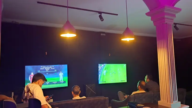 بازیکنان در گیم‌نت VIP PS5 پارس مشغول بازی فوتبال روی صفحه‌نمایش‌های بزرگ. تجربه‌ای لذت‌بخش در محیطی لوکس و مدرن برای گیمرها.