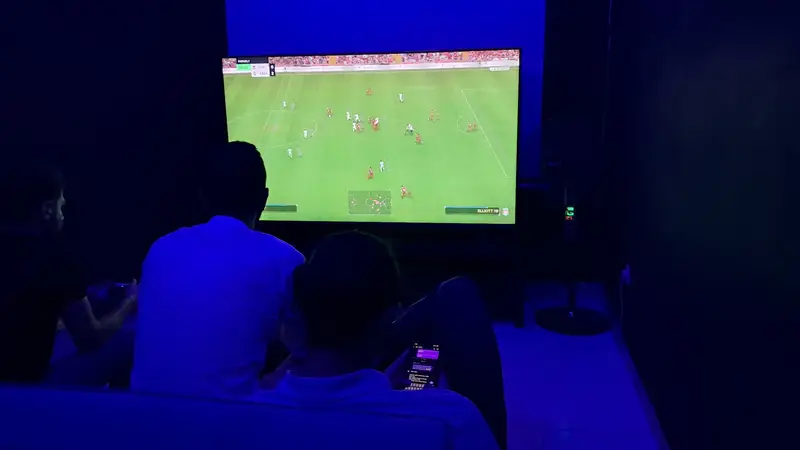 بازیکنان غرق در بازی فوتبال (FIFA/EAFC) با کنسول PS5 در گیم‌نت VIP پارس. تجربه هیجان‌انگیز و لوکس پلی استیشن با دوستان.