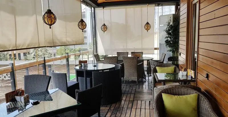 کافه رستوران پلاس ویونا: بالکن دلنشین و دنج با مبلمان حصیری راحت و دکوراسیون مدرن، ایده‌آل برای تجربه‌ای متفاوت.