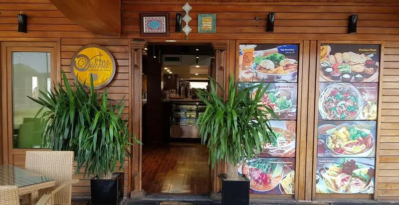 نمای بیرونی کافه رستوران پلاس ویونا با دکور چوبی، منو غذاهای متنوع ایرانی و بین‌المللی، و فضای نشستن در فضای باز.