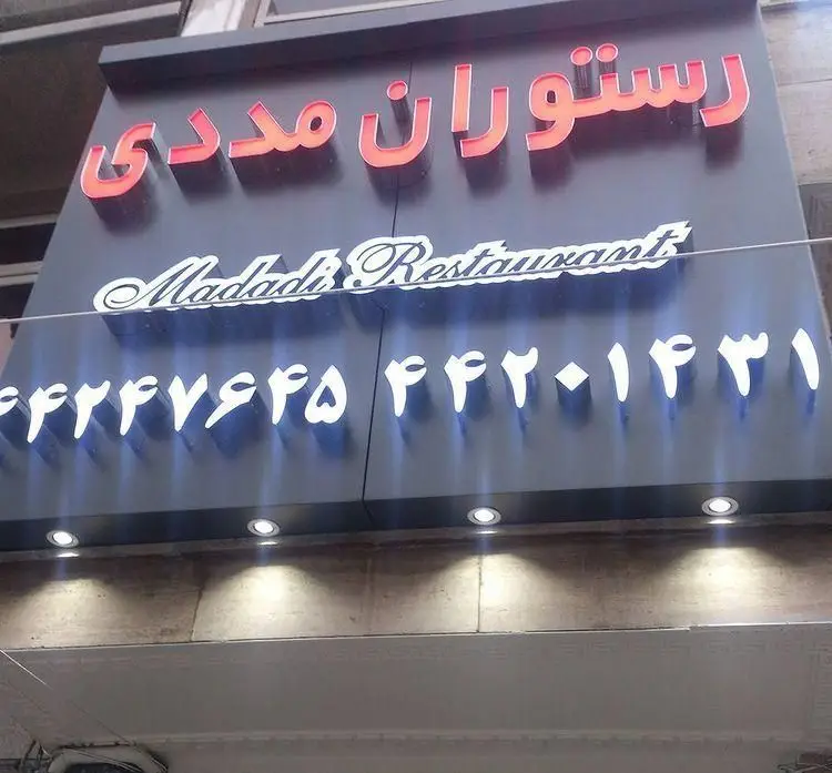 تابلوی رستوران و فست فود مددی (پیتزا مددی) با شماره‌های تماس، مکانی ایده‌آل برای سفارش آنلاین و حضوری غذای لذیذ.