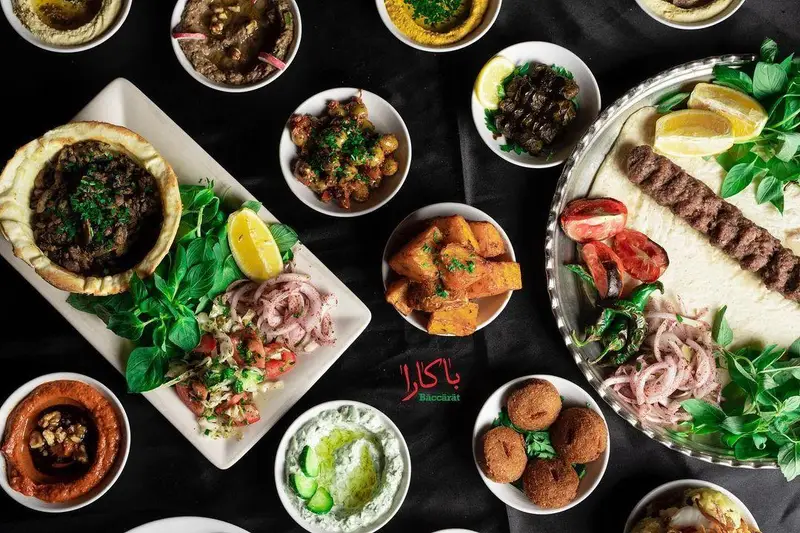تصویری هوایی از میز غذای رستوران لبنانی باکارا لانژ: کباب کوبیده، حمص، فلافل، باباغنوش، تبوله، مزه و سیب‌زمینی تند.
