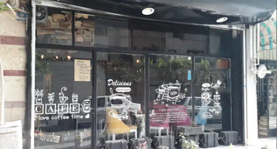 تصویر نمای بیرونی کافه قرار، کافی شاپی زیبا با ویترین شیشه‌ای، برچسب‌های هنری قهوه، شعار "love coffee time" و محیطی دلنشین برای مشتریان.