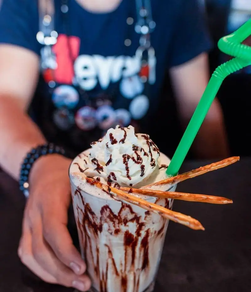 یک میلک شیک جذاب و خنک از کافه خیابون با خامه فراوان، سس شکلات، چوب شور و نی سبز. بهترین انتخاب برای یک روز گرم در کافه خیابون.