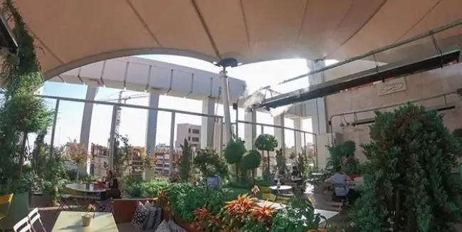 کافه فلورین، روف گاردن دلنشین با فضای سبز پرطراوت و میز و صندلی‌های شیک. محیطی آرام برای تجربه غذایی لذت‌بخش در فضای باز.