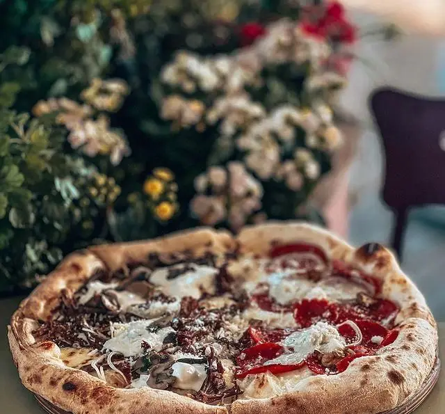 پیتزا دو طعم خوشمزه کافه فلورین با خمیر برشته، یک نیمه با سس سفید و قارچ و نیمه دیگر با پپرونی و پنیر. فضای دلنشین.