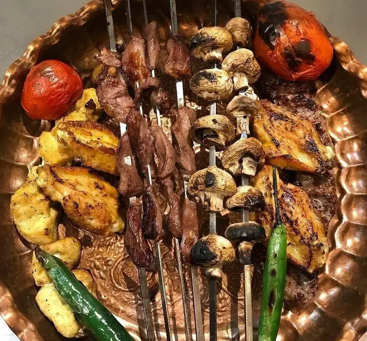 سینی کباب مخلوط لذیذ رستوران مارینو شامل جوجه کباب، کباب برگ، قارچ، گوجه و فلفل کبابی. یک تجربه غذایی اصیل ایرانی.