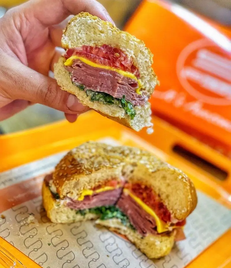 ساندویچ خوشمزه برگر اسلاید برگر با نان کنجدی، لایه های گوشت مرغوب، پنیر، گوجه و سبزیجات تازه. یک وعده غذایی کامل و لذیذ.