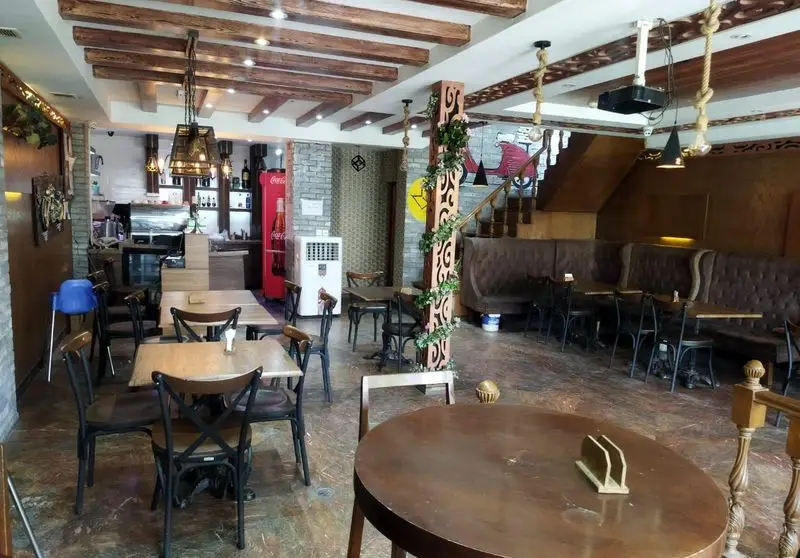 نمایی از فضای داخلی رستوران ایتالیایی ژولی با طراحی دکوراسیون خاص، میز و صندلی‌های چوبی، و محیطی دنج و آرام برای صرف غذا.