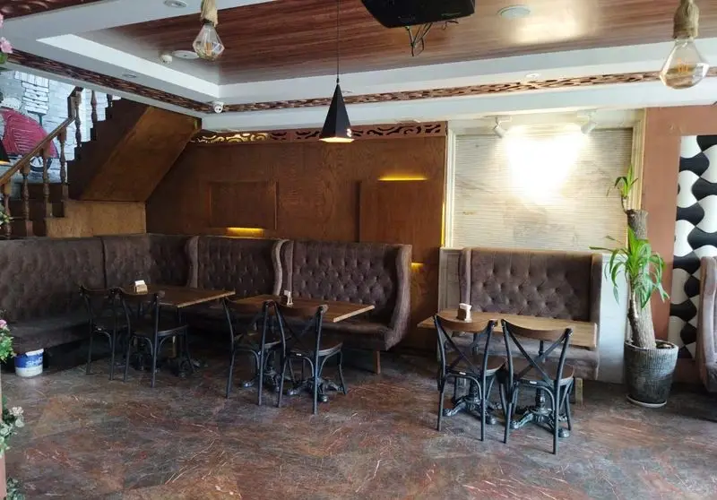 نمای داخلی رستوران ایتالیایی ژولی، فضایی گرم و دعوت‌کننده با صندلی‌های راحتی و میزهای چوبی برای تجربه‌ی یک غذای عالی.