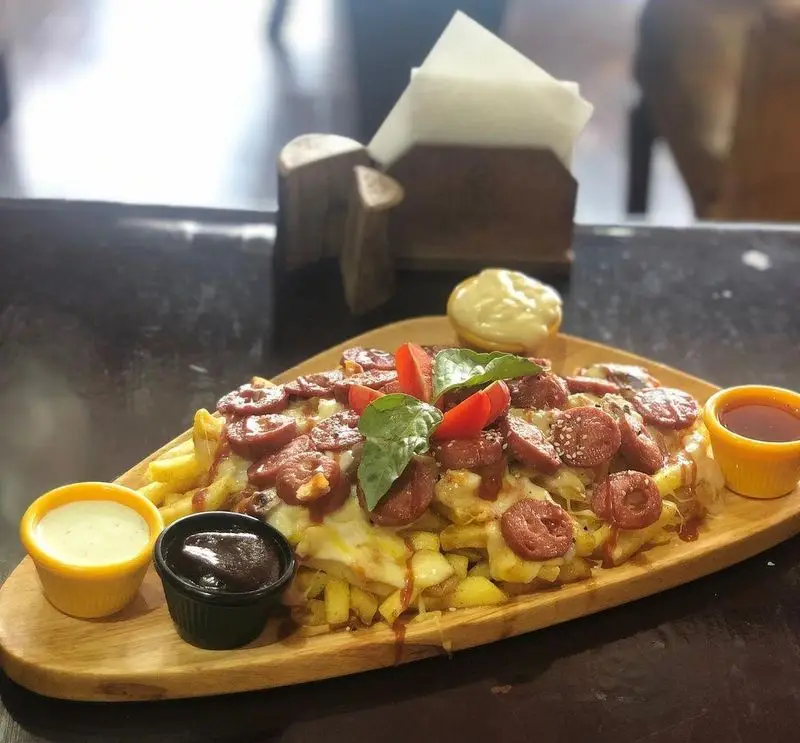 سیب‌زمینی سرخ کرده با سوسیس، پنیر آب شده و مخلفات خوشمزه در رستوران ایتالیایی ژولی، یک انتخاب عالی برای پیش‌غذا.