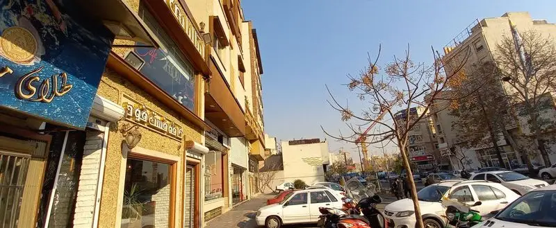 نمای بیرونی رستوران ایتالیایی ژولی در یک روز آفتابی، با ساختمان‌ها و خودروهای پارک شده در خیابان شهر.