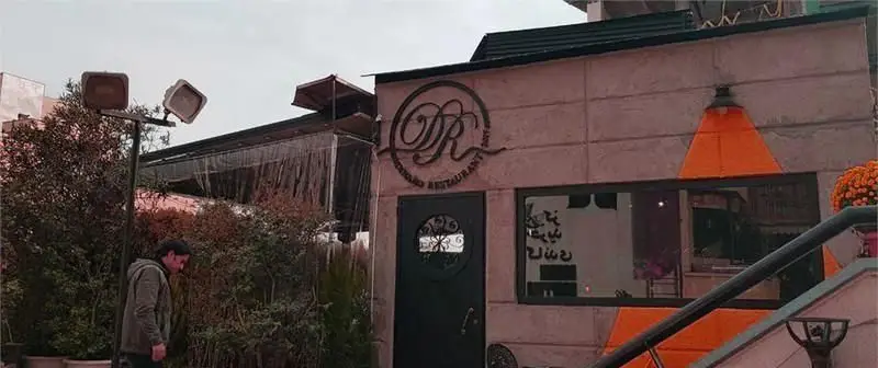 نمای بیرونی شیک و مدرن کافی شاپ و رستوران دینارو با فضای سبز، نورپردازی خاص و دکوراسیون منحصربه‌فرد، آماده میزبانی از شما.