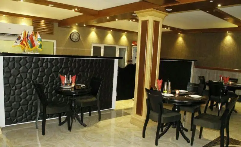 فضای داخلی رستوران ایتالیایی لان چای با دکوراسیون مدرن، میز و صندلی‌های شیک، پنل دیواری جذاب و نورپردازی گرم، محیطی دلپذیر برای مشتریان.