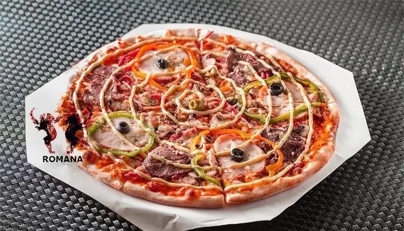 پیتزا مجلل رومانا با طراحی منحصر به فرد و مخلفات تازه فلفل دلمه‌ای، زیتون و گوشت. تجربه غذای ایتالیایی در رومانا.