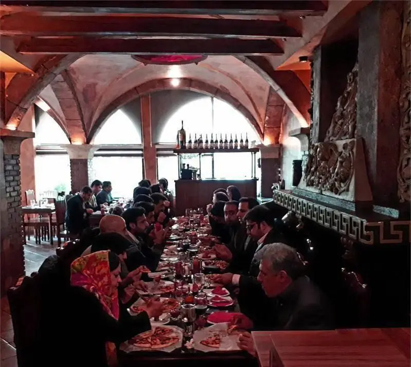 رستوران ایتالیایی رومانا، فضایی با سقف‌های طاقی و پنجره‌های بزرگ، مشتریان مشغول صرف پیتزاهای تازه و غذاهای ایتالیایی لذیذ در محیطی دلپذیر.