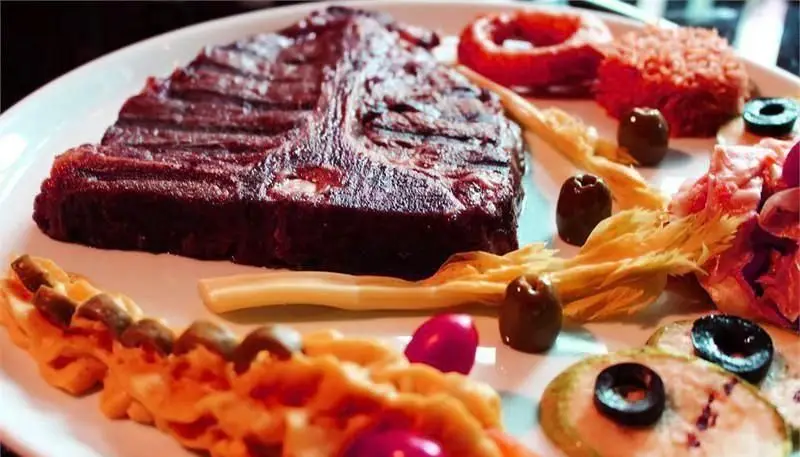 تصویری از یک استیک عالی و غذاهای جانبی متنوع در رستوران ایتالیایی رومانا، بهترین انتخاب برای تجربه‌ یک غذای ایتالیایی اصیل و فراموش نشدنی.