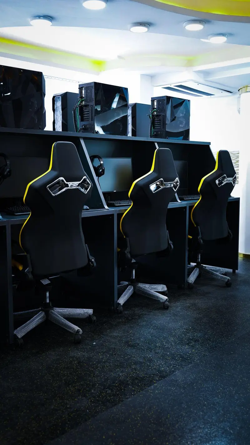 نمایی از گیم سنتر اسکوآد، محیطی ایده‌آل برای بازی با کامپیوترهای گیمینگ پیشرفته، مانیتورها و صندلی‌های راحت مشکی زرد.