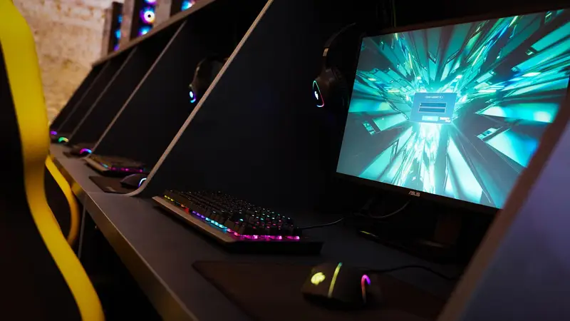 گیم سنتر اسکوآد: ردیفی از ایستگاه‌های گیمینگ با کامپیوترهای قدرتمند، نورپردازی RGB خیره‌کننده و محیطی ایده‌آل برای گیمرهای حرفه‌ای.