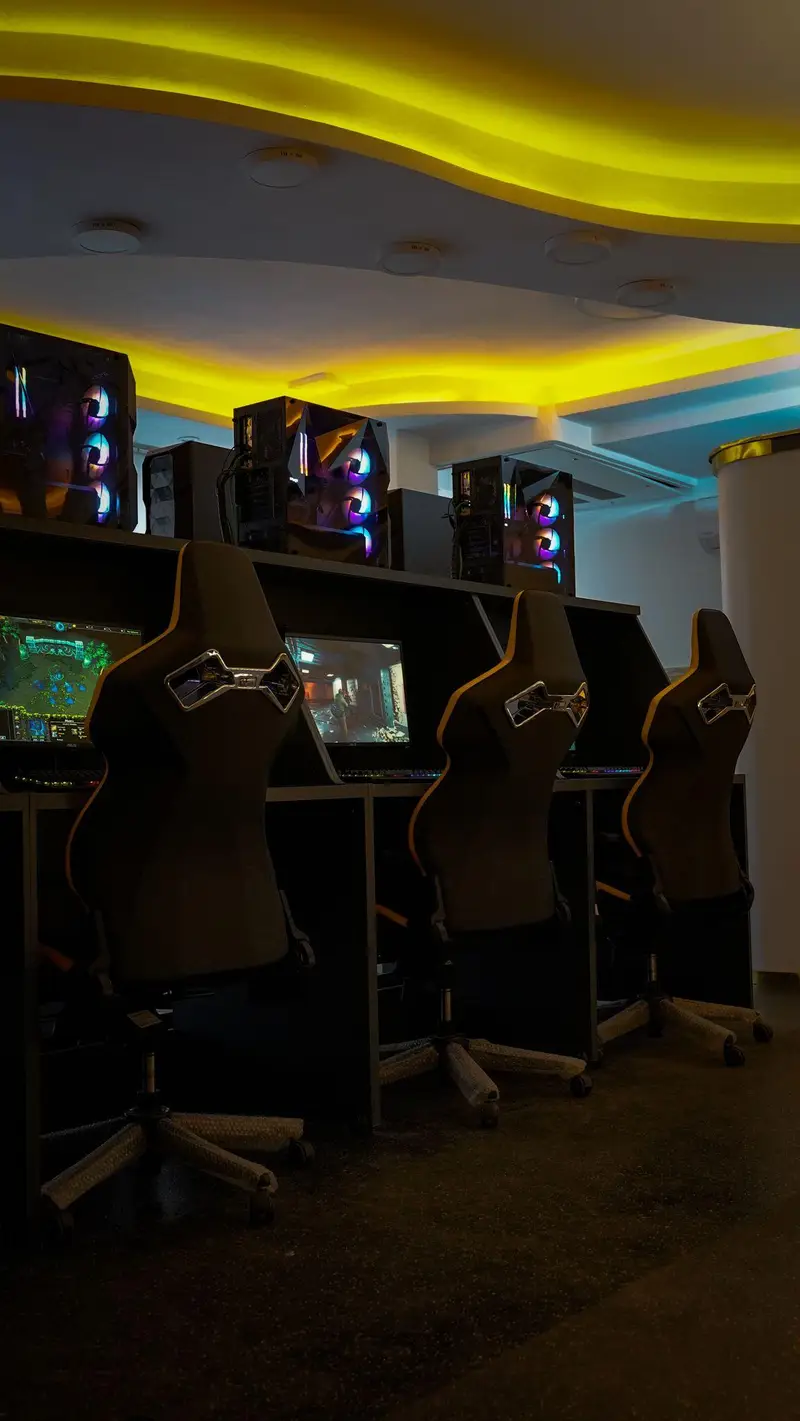 فضای داخلی گیم سنتر اسکوآد: ایستگاه‌های بازی مجهز به کامپیوترهای گیمینگ RGB و صندلی‌های حرفه‌ای، آماده برای رقابت و سرگرمی.