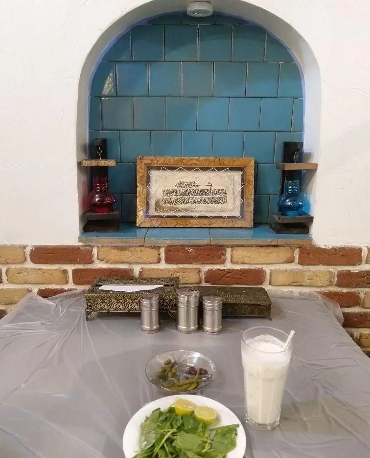 میز چیده شده در جگرسرای بابا علی با سبزی تازه، زیتون و دوغ؛ فضایی سنتی و دلنشین برای سرو جگر کباب.