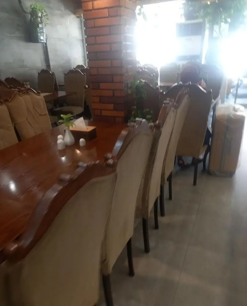 فضای داخلی دلنشین رستوران سرآشپز، با میزهای چوبی بزرگ و صندلی‌های راحت، مناسب برای سرو غذا و دورهمی‌های خانوادگی در محیطی آرام.