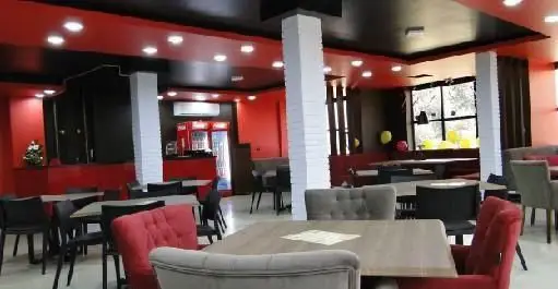 فضای داخلی فست فود آماندا، رستورانی با طراحی مدرن و دلپذیر، دکوراسیون قرمز و مشکی، و میز و صندلی‌های شیک برای پذیرایی