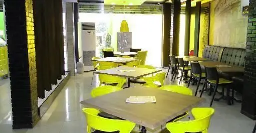 فضای داخلی مدرن و شیک فست فود آماندا با میز و صندلی‌های زرد روشن و محیطی دلنشین برای صرف غذاهای سریع و لذیذ.