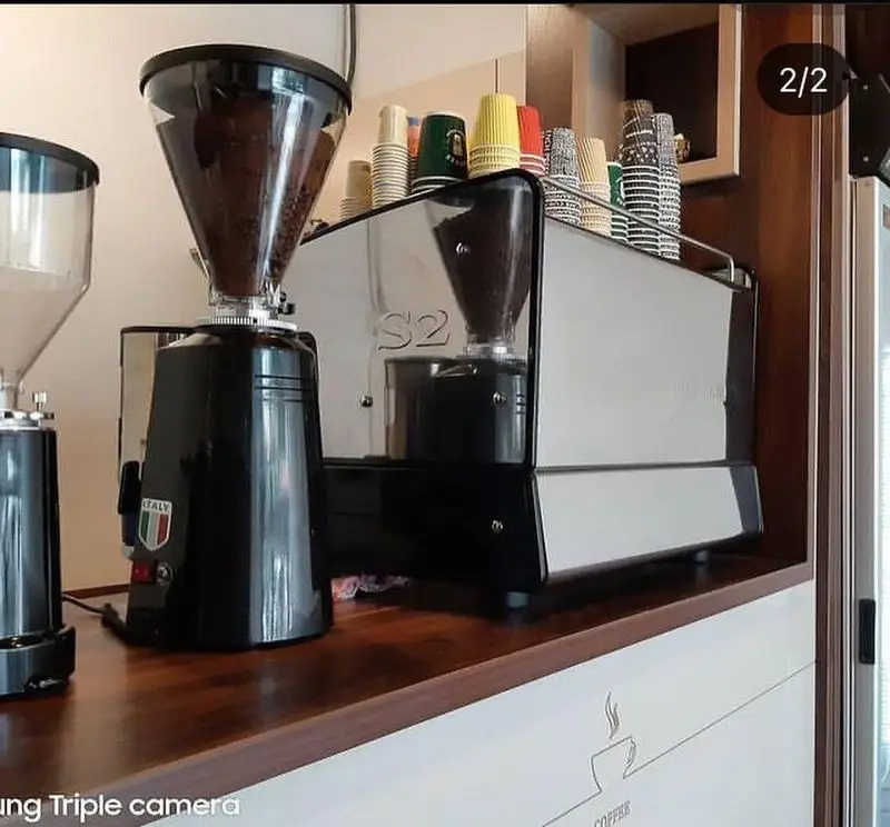 تجهیزات مدرن کافه باران شامل دستگاه اسپرسو S2 و دو آسیاب قهوه برای آماده‌سازی بهترین قهوه و نوشیدنی‌های گرم با دانه‌های تازه.