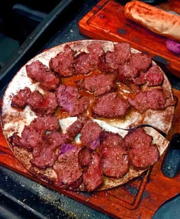 تکه های آبدار استیک گریل شده روی سینی داغ، آماده سرو در مم مد استیک هاوس. غذای لذیذ و تازه فست فود و گریل.