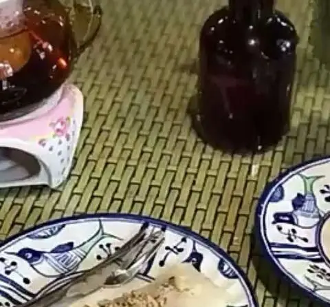 میز چای و دسر در رستوران شمالی گیله گل با قوری چای، بطری و بشقاب‌های سنتی طرح‌دار حاوی شیرینی یا دسر.