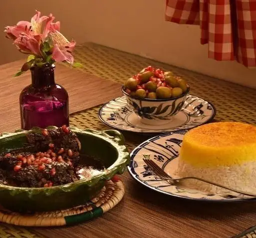 سفره شیک رستوران شمالی گیله گل با خورش محلی اناربیج، ته دیگ زعفرانی و زیتون پرورده. غذای سنتی گیلان.