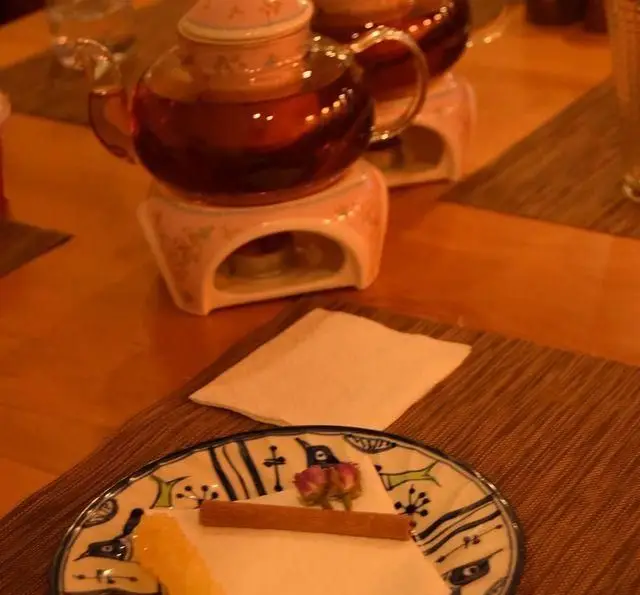 چای داغ و دسری لذیذ در رستوران شمالی گیله گل، شامل کیک و تزئینات زیبا. لحظاتی دلنشین در فضایی دنج و صمیمی برای مهمانان.