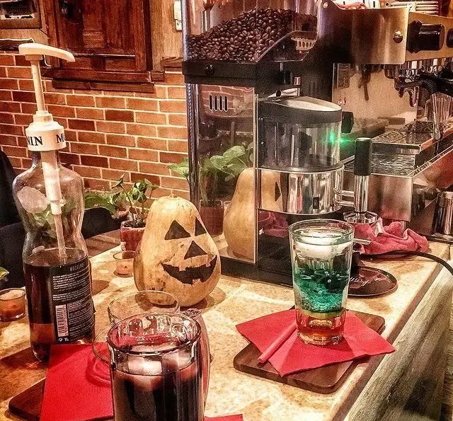 فضای پاییزی کافه پندار با دکوراسیون هالووین، دستگاه قهوه، نوشیدنی‌های رنگارنگ و یک کدو تنبل حکاکی شده. تجربه‌ای دلپذیر از قهوه و نوشیدنی.