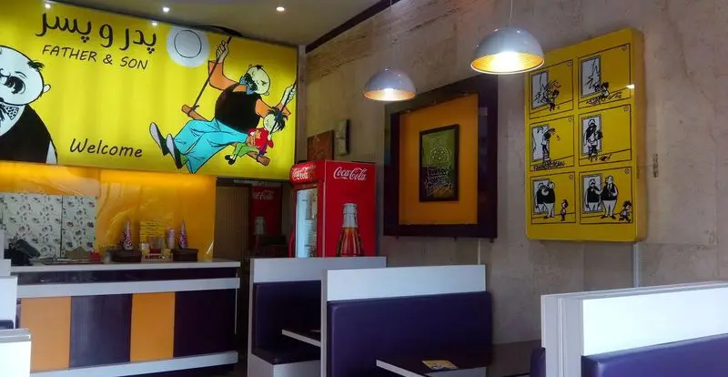 فضای داخلی و دکوراسیون جذاب رستوران پیتزا پدر و پسر با طرح‌های کارتونی، نیمکت‌های بنفش و پیشخوان رنگارنگ