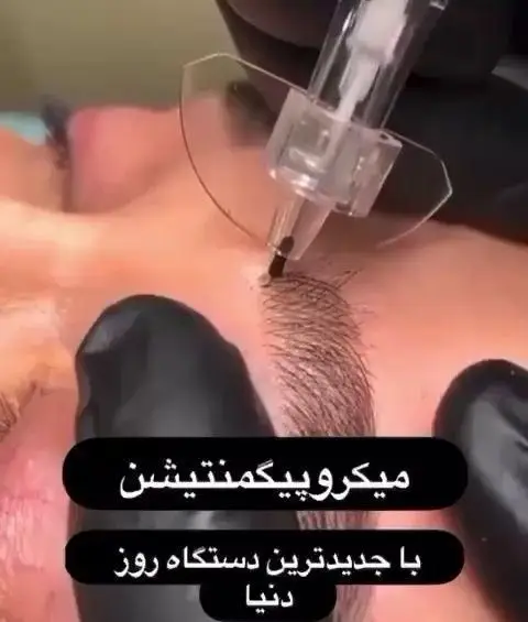 تصویر نمای نزدیک از انجام میکروپیگمنتیشن ابرو با دستگاه مخصوص توسط اپراتور با دستکش مشکی در سالن آرایش و زیبایی سیندرلا