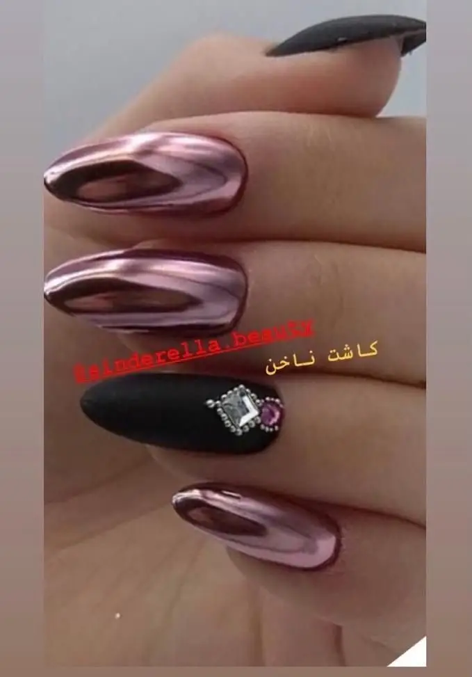 تصویر نمونه طراحی و کاشت ناخن بلند با لاک کروم آینه‌ای صورتی و ناخن مشکی دیزاین شده با نگین در سالن زیبایی سیندرلا