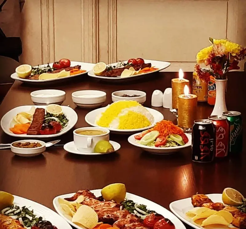 میز پر از غذاهای لذیذ در رستوران اقدسیه: کباب‌های آب‌دار، برنج زعفرانی، سالادهای تازه و محیطی دلنشین برای صرف شام.